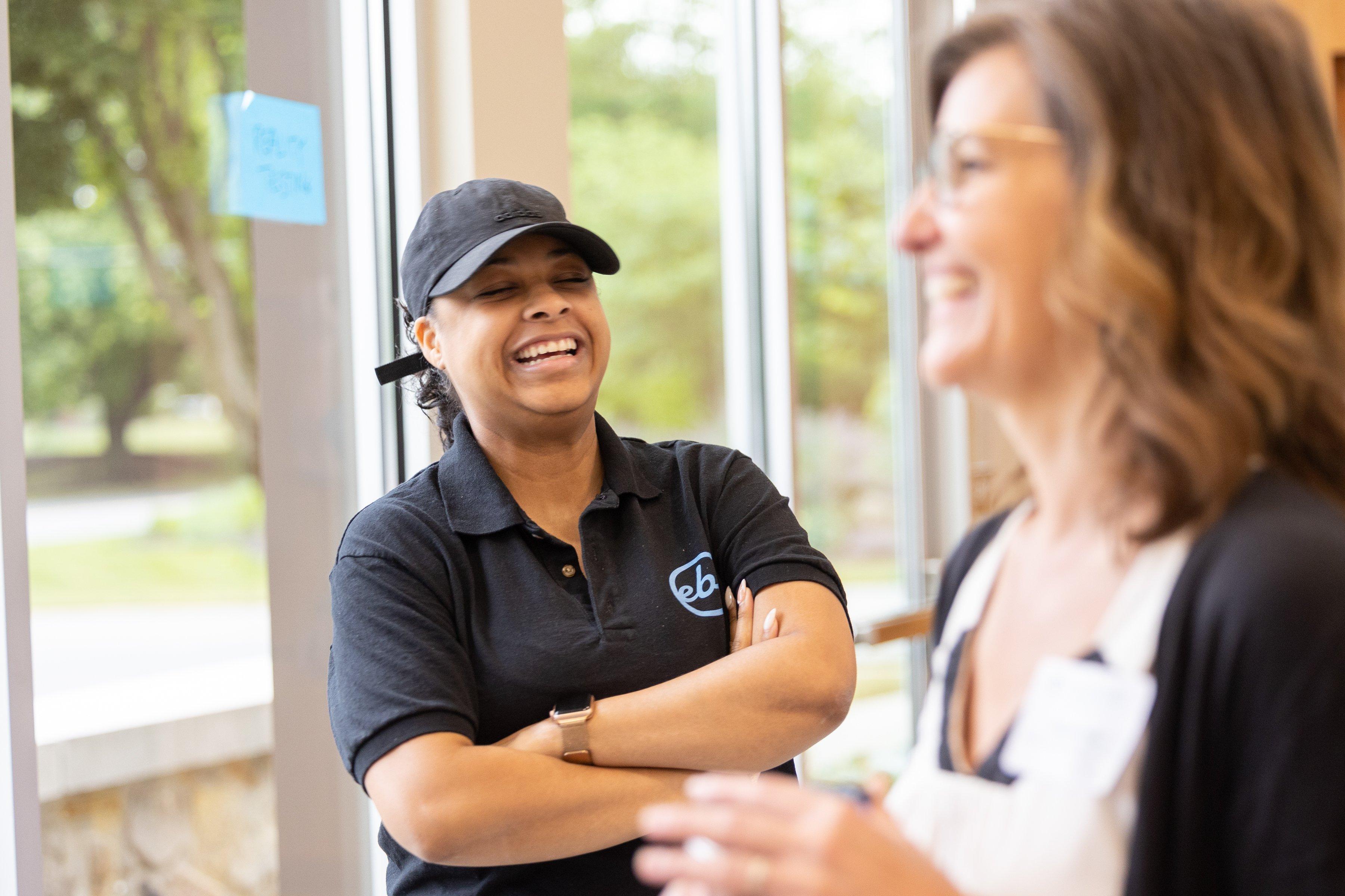 Two adult women laughing. 