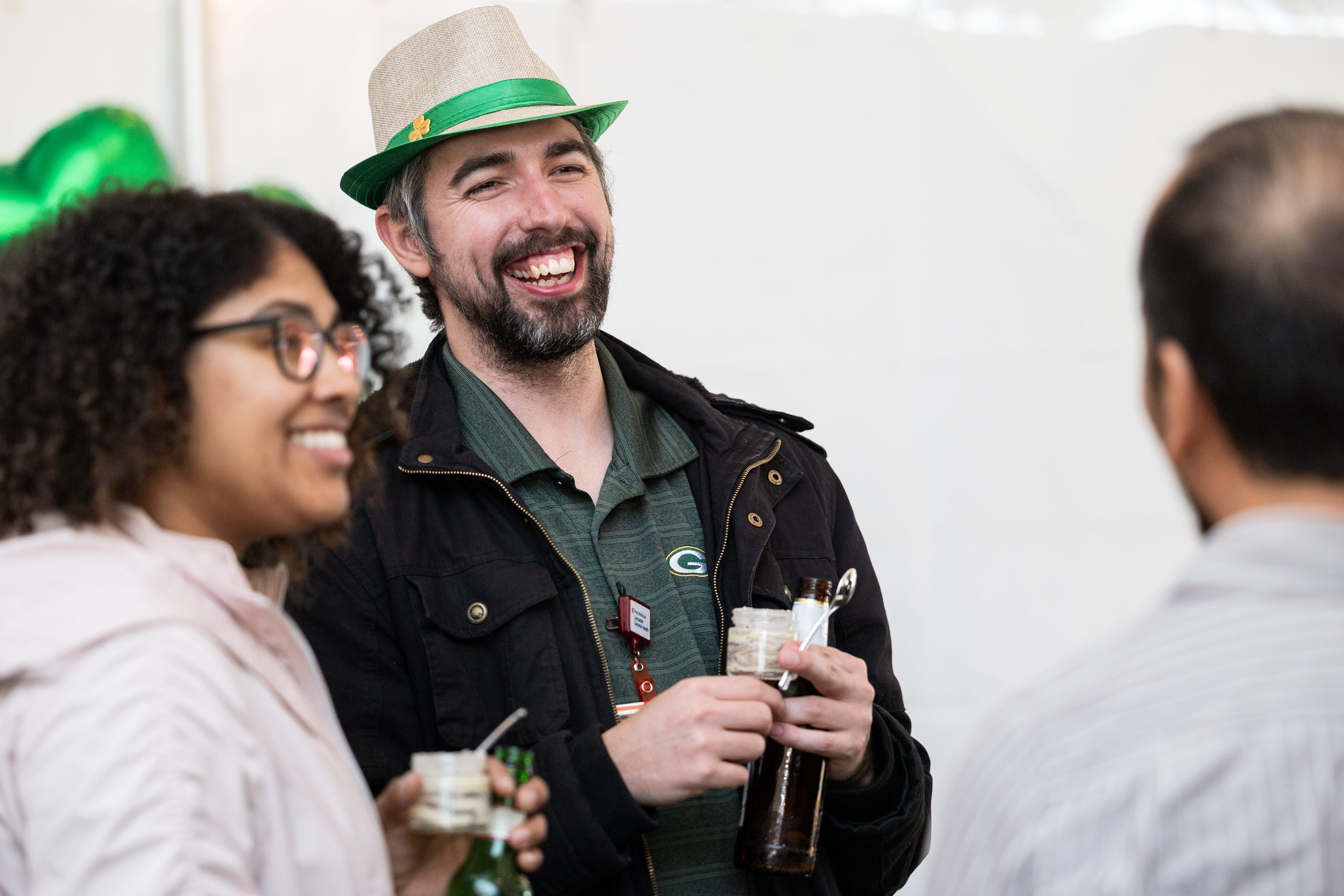 Man and woman smiling at another person during a networking event. 