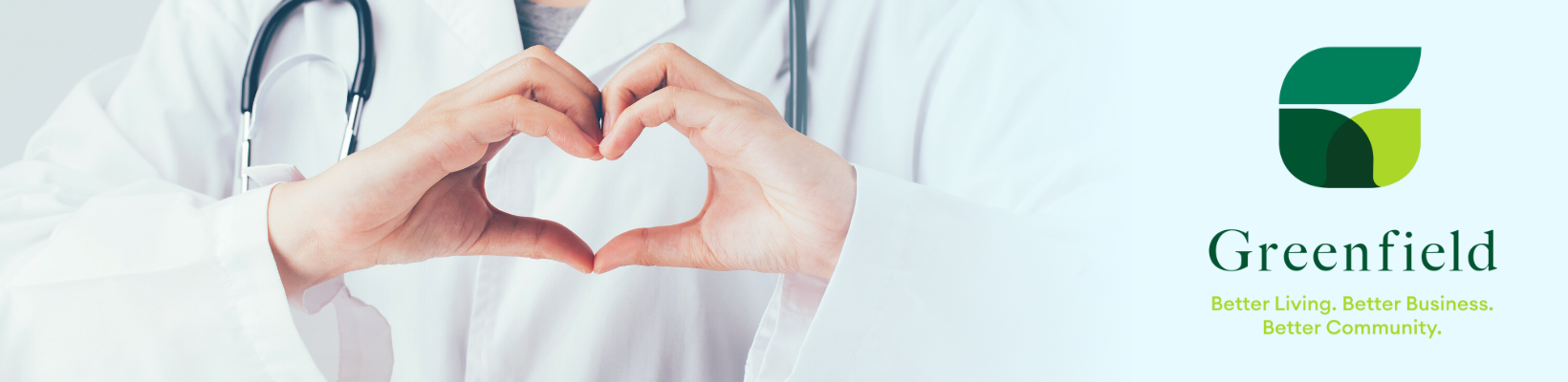 Doctor in white over coat making his hands in the shape of a heart. 